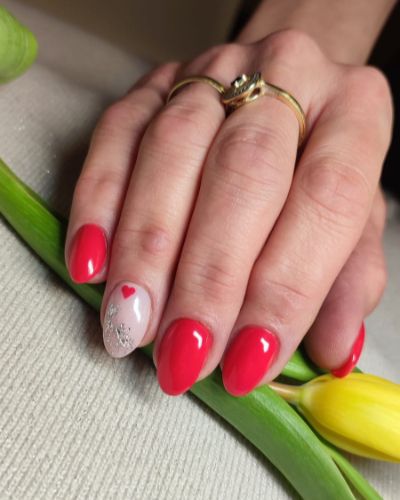 czerwony manicure hybrydowy z kwiatkiem na palcu serdecznym